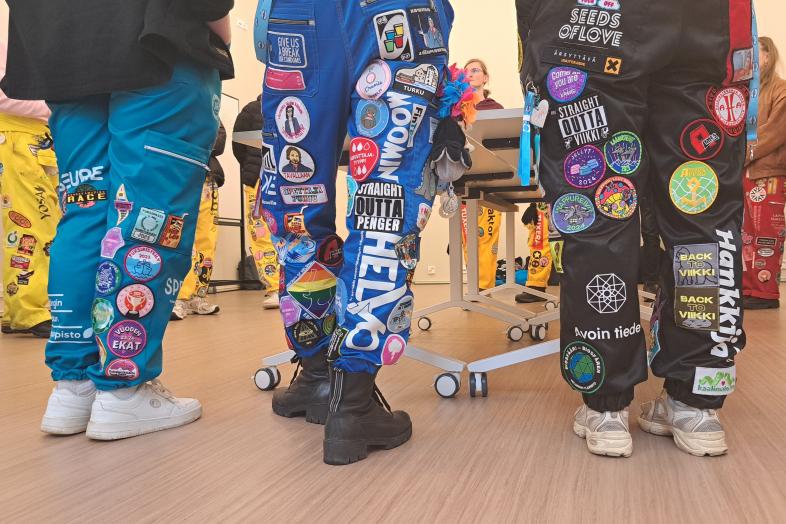 Haalariasuisia opiskelijoita luentosalissa.