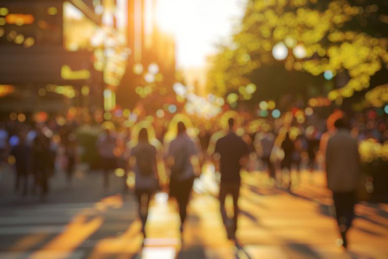 Ihmisiä kävelemässä kadulla auringonlaskussa.