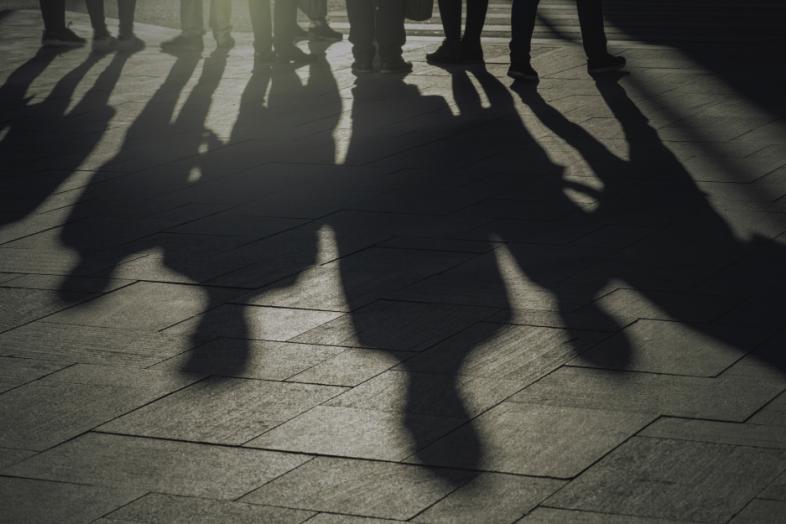 Ihmisten varjoja kadulla.