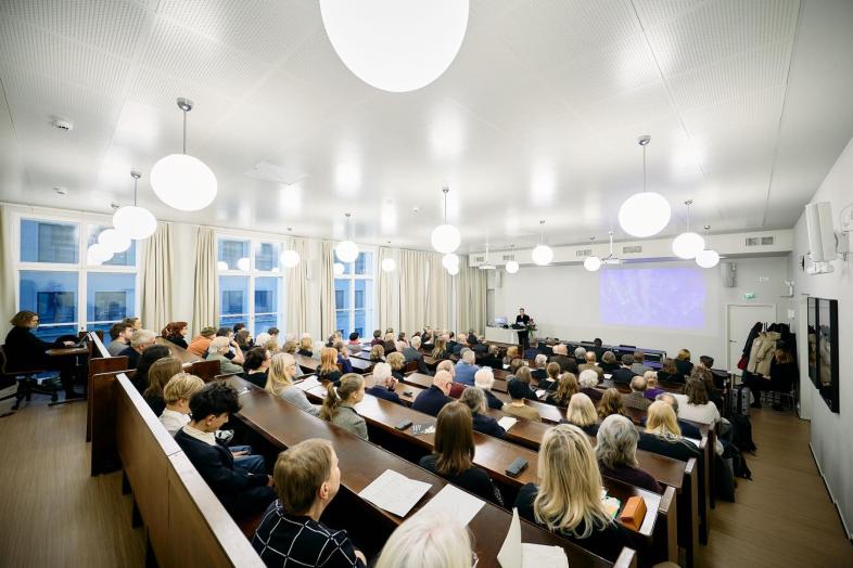 Yleisöä kuuntelemassa juhlaluentoa.