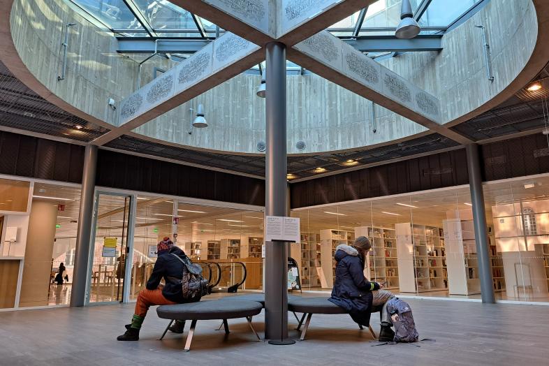 Alexandria, aulatila, kaksi henkilöä istuu penkillä. Kuvan ottanut Anniina Sjöblom.